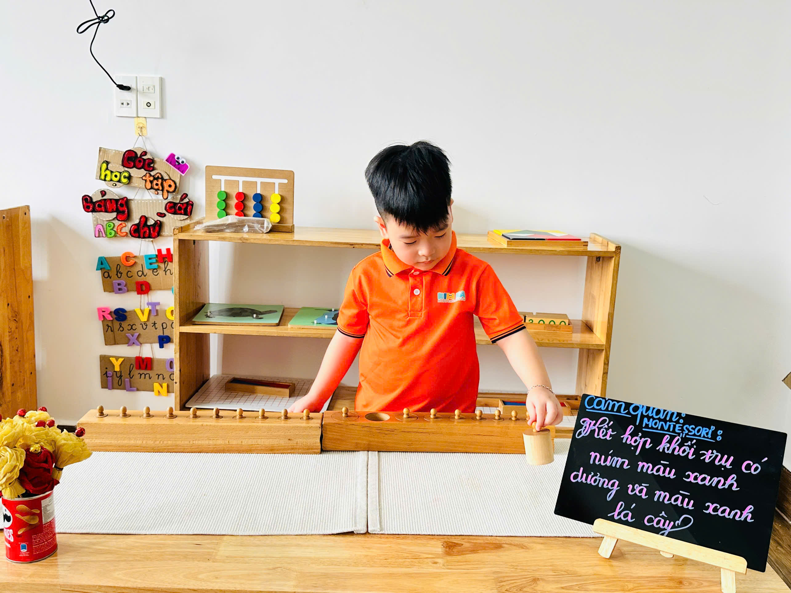 Bé lớp Clownfish làm việc với bộ khối trụ có núm Montessori