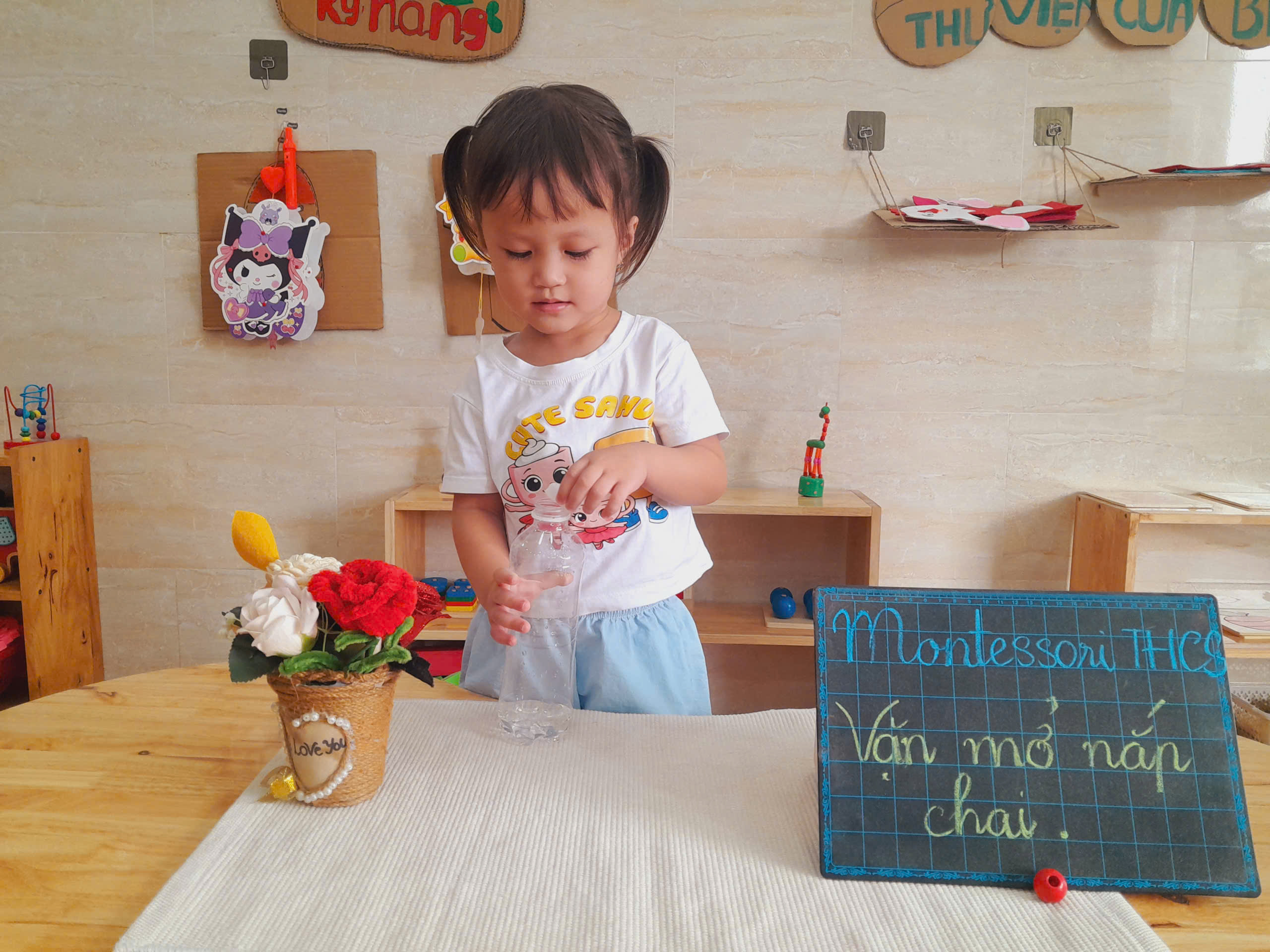 Bé tập trung thực hành bài tập vặn mở nắp chai Montessori